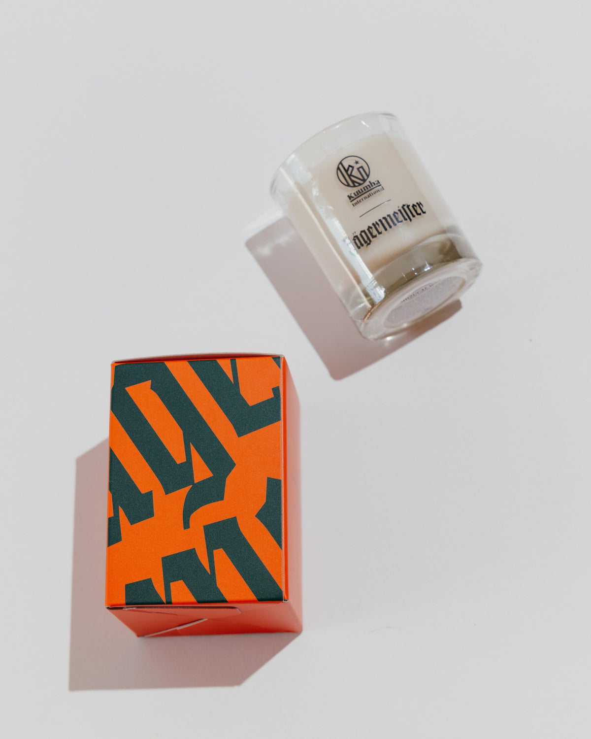 Jägermeister candle with decorative box with Jägermeister wordmark in green and orange