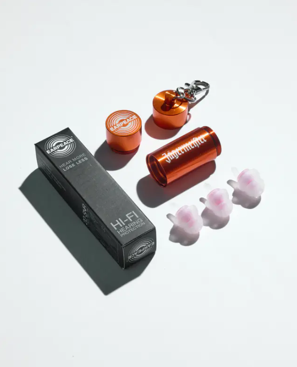Three earplugs, an orange metal case with a white Jägermeister wordmork on it and a black packaging box  in a white background