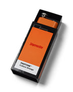 Oranje Jägermeister-drinkfles in een zwarte doos met 'PANTONE Culture Orange'-label op een witte achtergrond