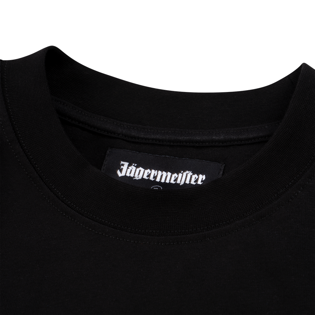 Close-up van de kraag van een zwart Jägermeister-T-shirt met een geweven Jägermeister-logolabel aan de binnenkant van de halslijn.