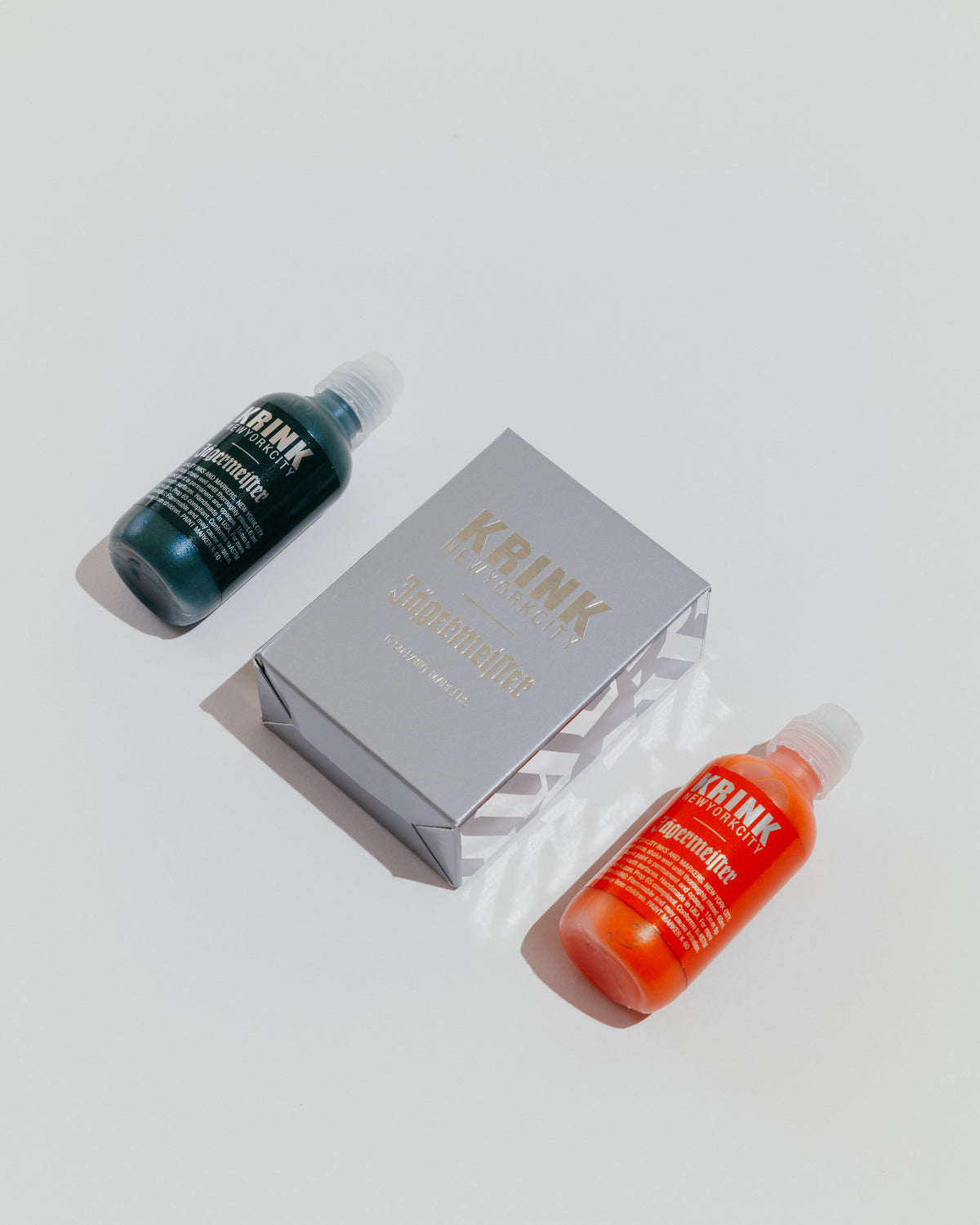 Two bottles of Krink paint markers and a Krink branded box 