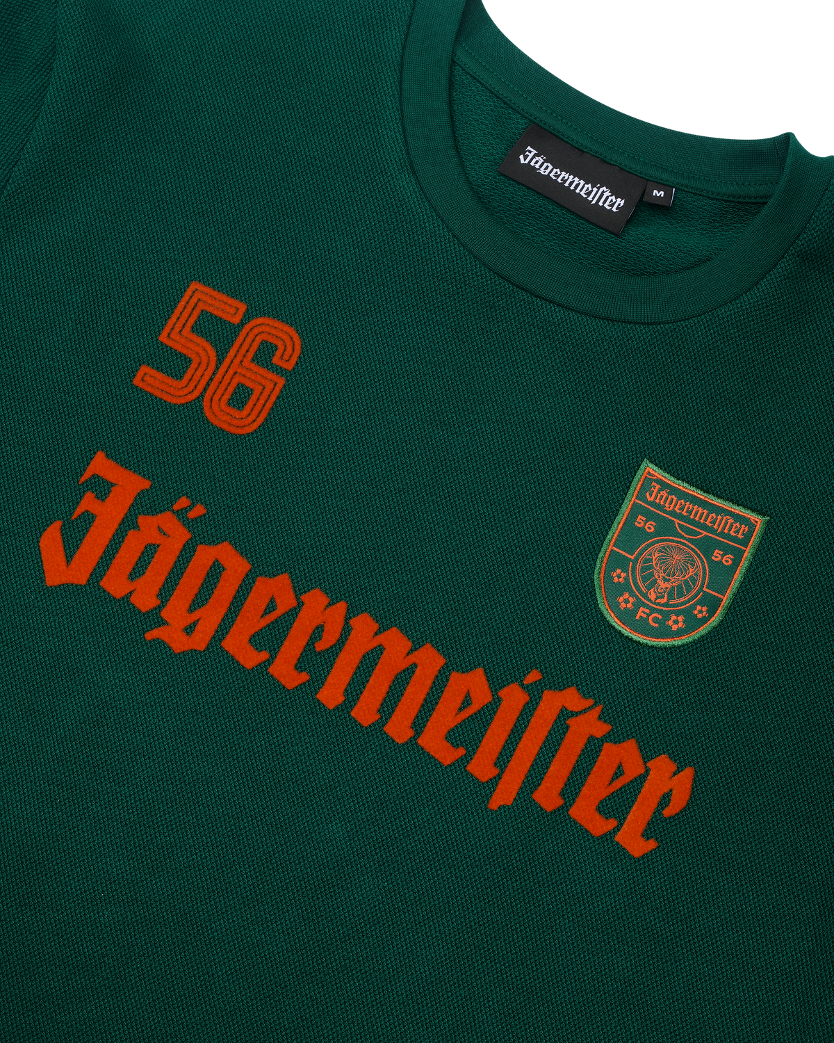 Green Jägermeister longsleeve with orange Jägermeister wordmark and a '56'.