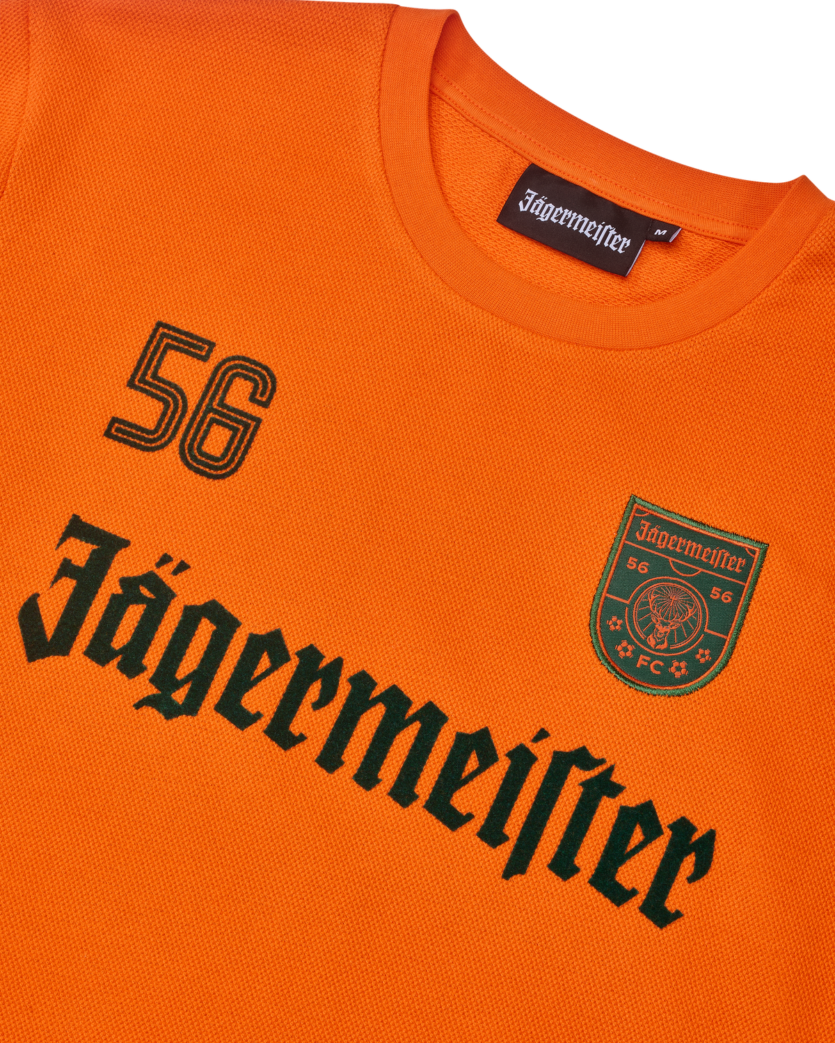 Orange Jägermeister longsleeve with black Jägermeister wordmark and a '56'.