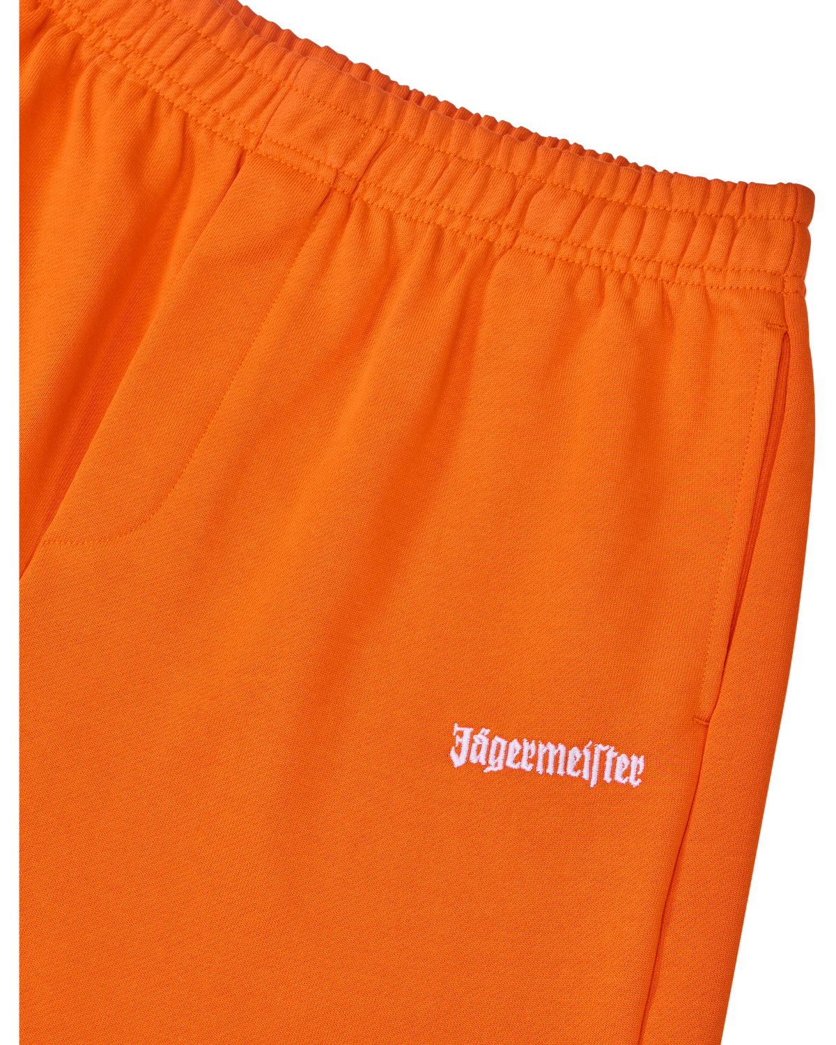 Close-up of orange pants with white Jägermeister logo.