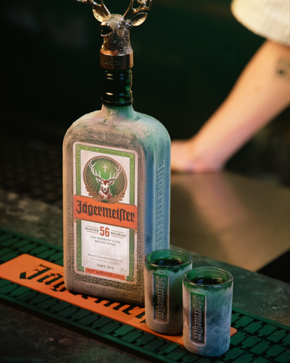 Jagermeister bottle with two shot glasses on a bar counter