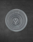 White Jägermeister shot glas from the top with stag logo on the bottom
