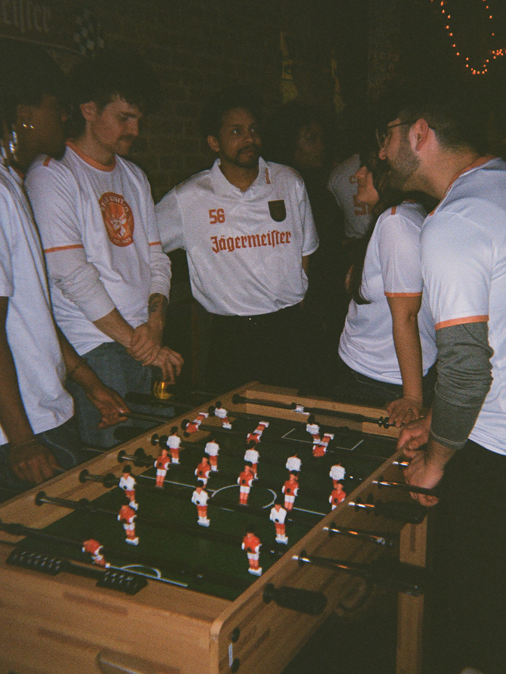 Group of people playing table kicker in a casual setting